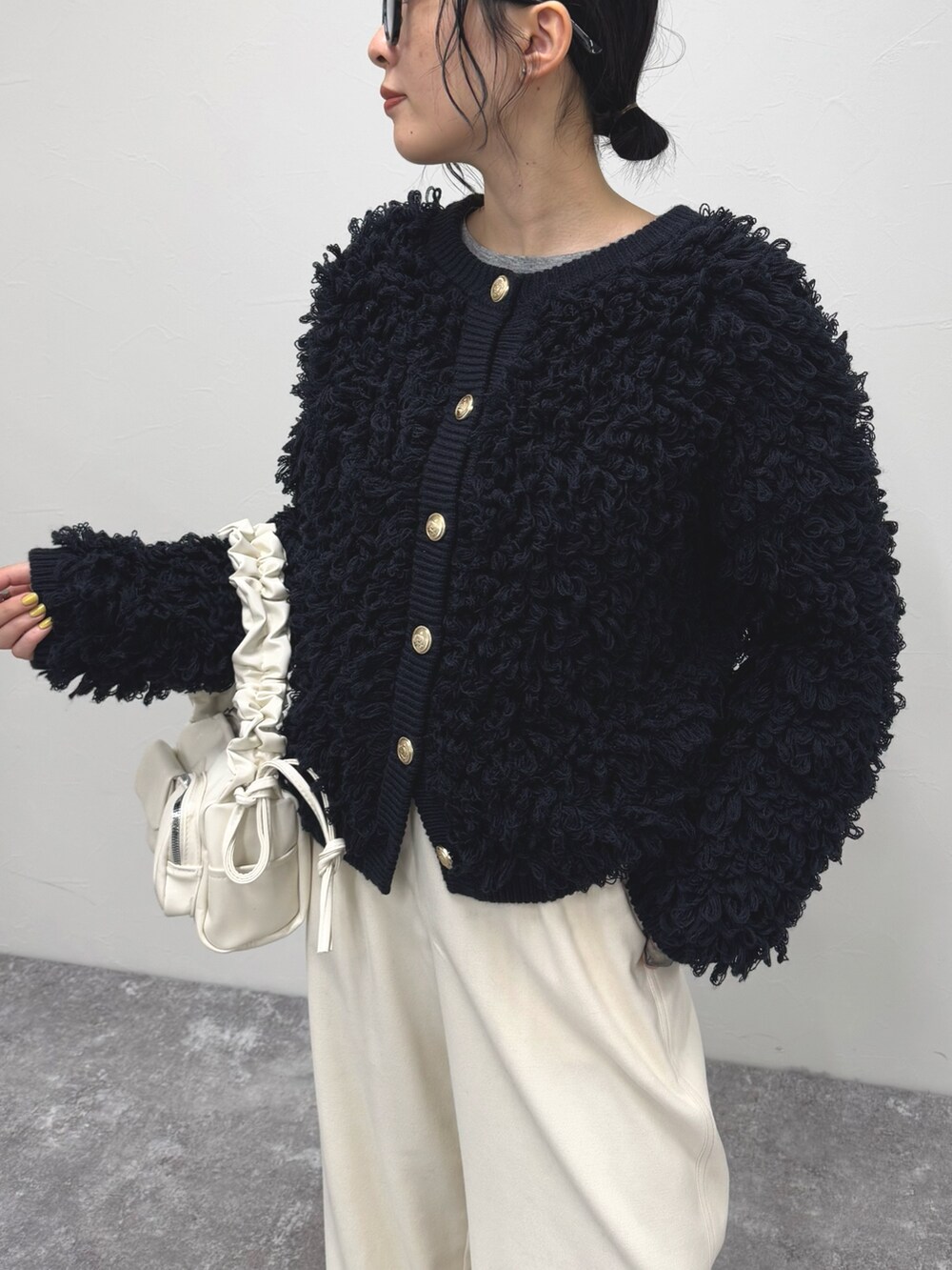 ブルー系のカーディガン/ボレロ、ホワイト系のその他パンツ、ホワイト系のハンドバッグを着用したレディースの冬コーディネートの5枚目の写真