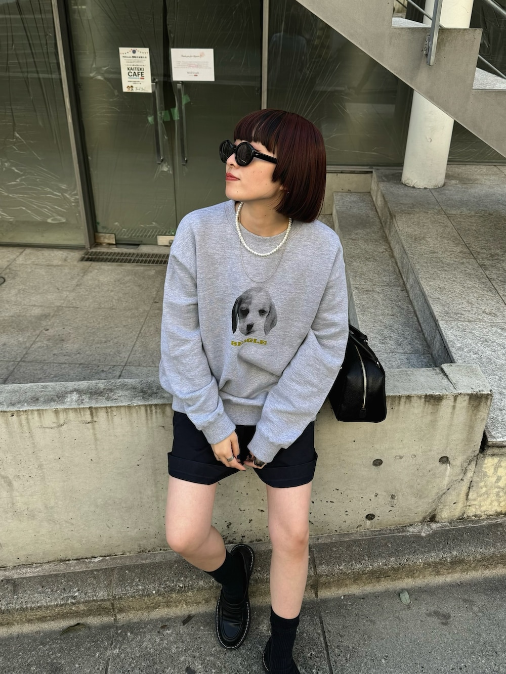 グレー系のスウェット、ブラック系のボストンバッグ、ブラック系のローファーを着用したレディースの春コーディネートの4枚目の写真