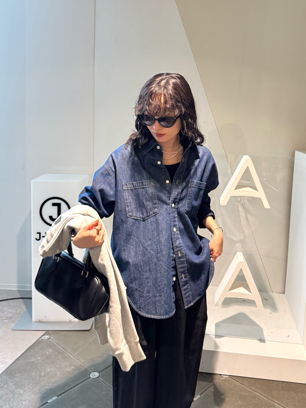グレー系のスウェット、ブラック系のその他パンツ、ブラック系のショルダーバッグを着用したレディースの春コーディネートの5枚目の写真