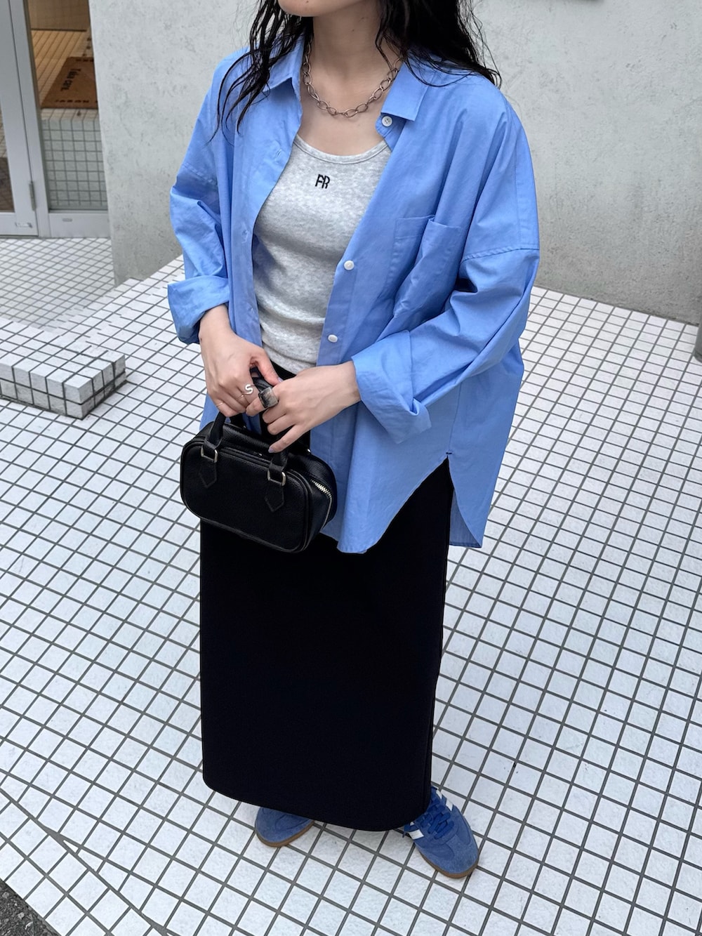 ブルー系のシャツ/ブラウス、グレー系のタンクトップ、ブラック系のスカートを着用したレディースの春コーディネートの4枚目の写真