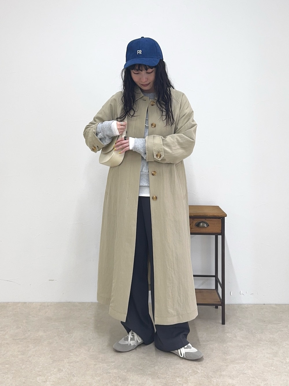 ベージュ系のステンカラーコート、グレー系のスウェット、ホワイト系のTシャツ/カットソーを着用したレディースの春コーディネートの2枚目の写真