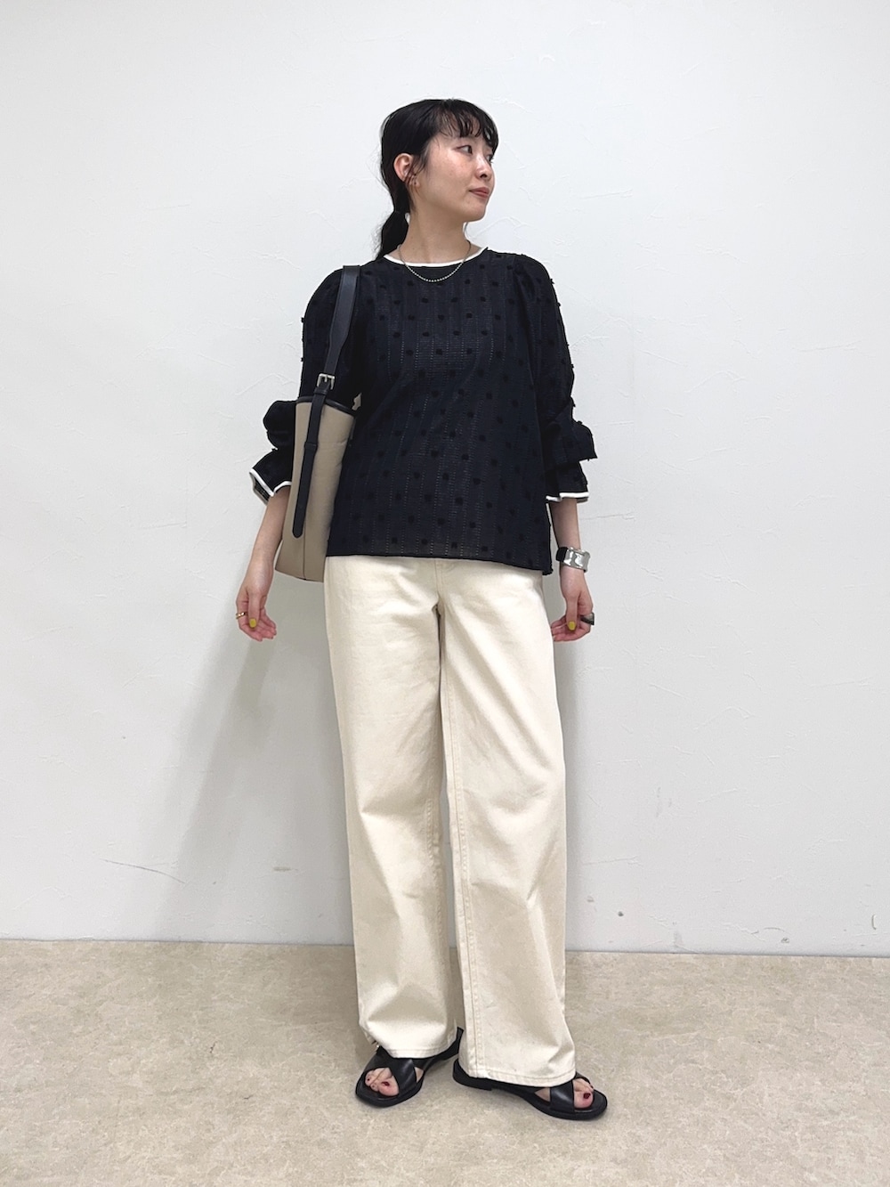 ブラック系のシャツ/ブラウス、ホワイト系のデニムパンツ、ブラック系のショルダーバッグを着用したレディースの春コーディネートの2枚目の写真