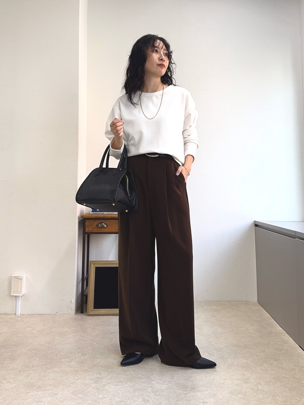 ホワイト系のTシャツ/カットソー、ブラック系のショルダーバッグ、ブラウン系のスラックスを着用したレディースの夏コーディネートの7枚目の写真