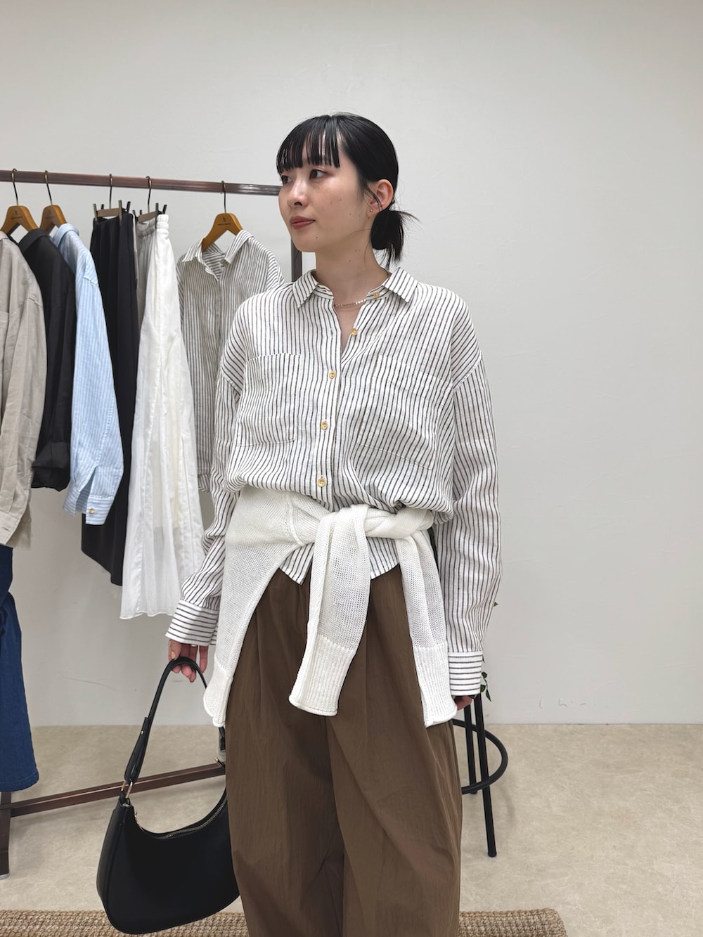 ベージュ系のシャツ/ブラウス、ブラウン系のその他パンツ、ホワイト系のニット/セーターを着用したレディースの春コーディネートの4枚目の写真