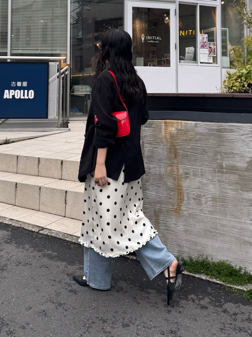 ホワイト系のスカート、ブルー系のデニムパンツ、レッド系のショルダーバッグを着用したレディースの春コーディネートの3枚目の写真