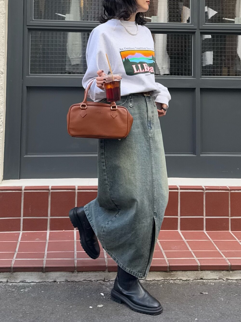 ブルー系のデニムスカート、イエロー系のショルダーバッグを着用したレディースの冬コーディネートの2枚目の写真