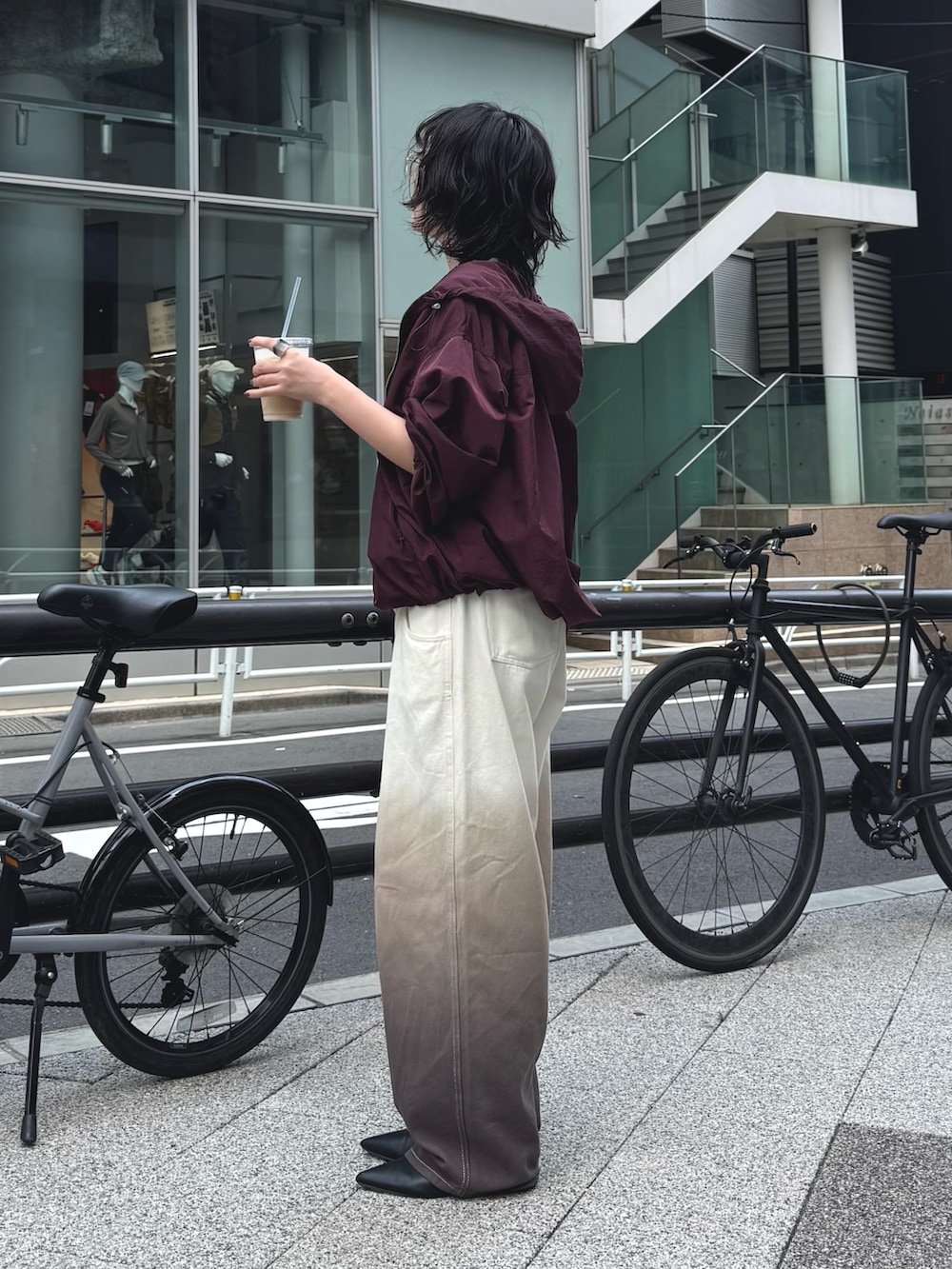 レッド系のブルゾン、ホワイト系のTシャツ/カットソー、ブラウン系のデニムパンツを着用したレディースの秋コーディネートの2枚目の写真