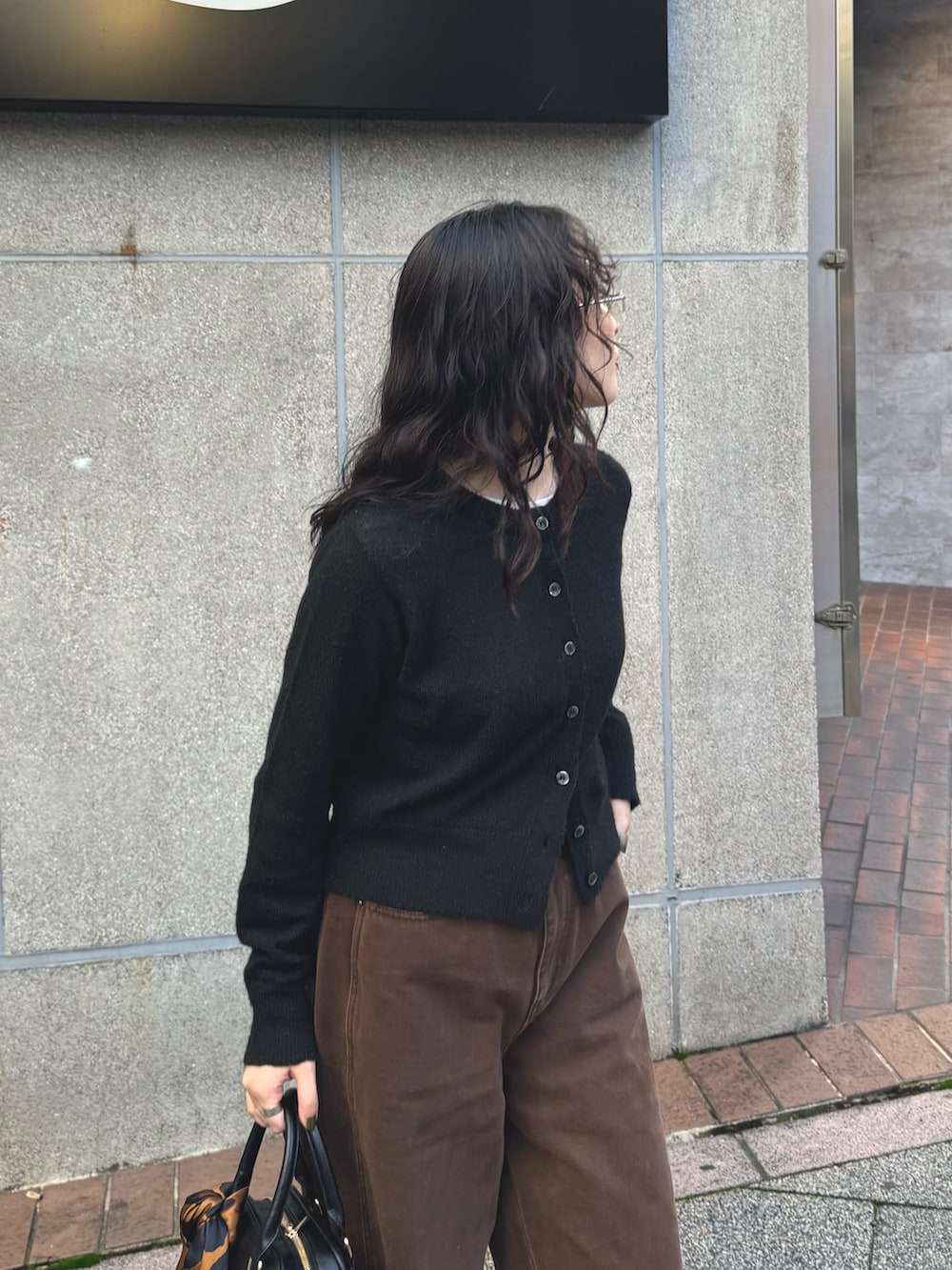 ブラック系のカーディガン/ボレロ、ブラウン系のその他パンツ、ブラック系のショルダーバッグを着用したレディースの秋コーディネートの3枚目の写真