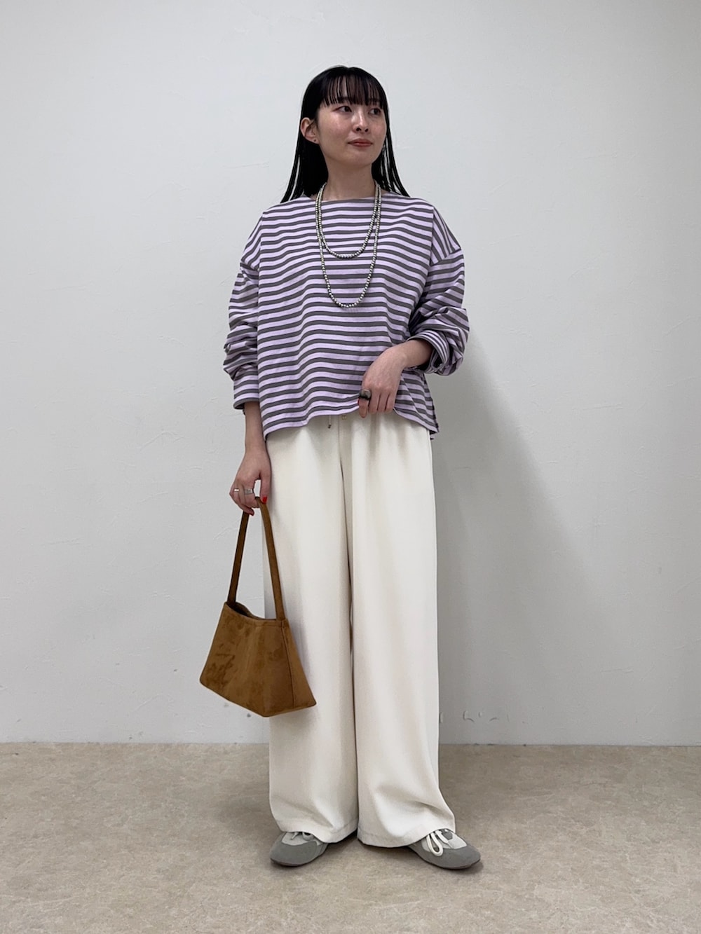 パープル系のTシャツ/カットソー、ホワイト系のその他パンツ、イエロー系のショルダーバッグを着用したレディースの冬コーディネートの6枚目の写真