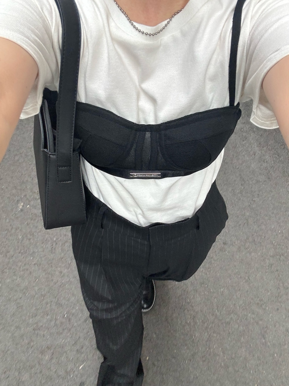 ホワイト系のTシャツ/カットソー、ブラック系のスラックス、ブラック系のハンドバッグを着用したレディースの夏コーディネートの4枚目の写真