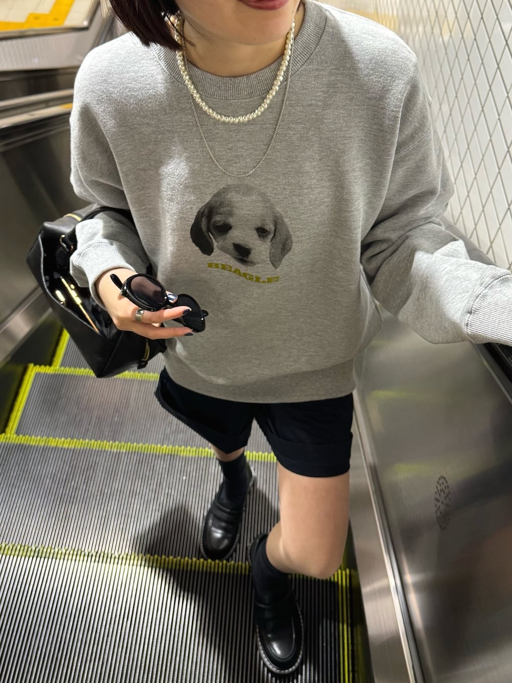 グレー系のスウェット、ブラック系のボストンバッグ、ブラック系のローファーを着用したレディースの春コーディネートの5枚目の写真