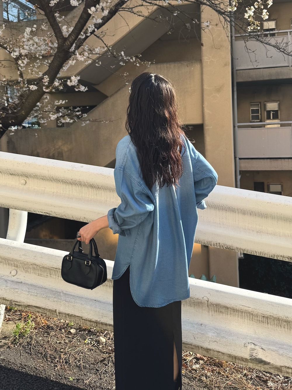 ブルー系のシャツ/ブラウス、ブラック系のスカートを着用したレディースの春コーディネートの8枚目の写真