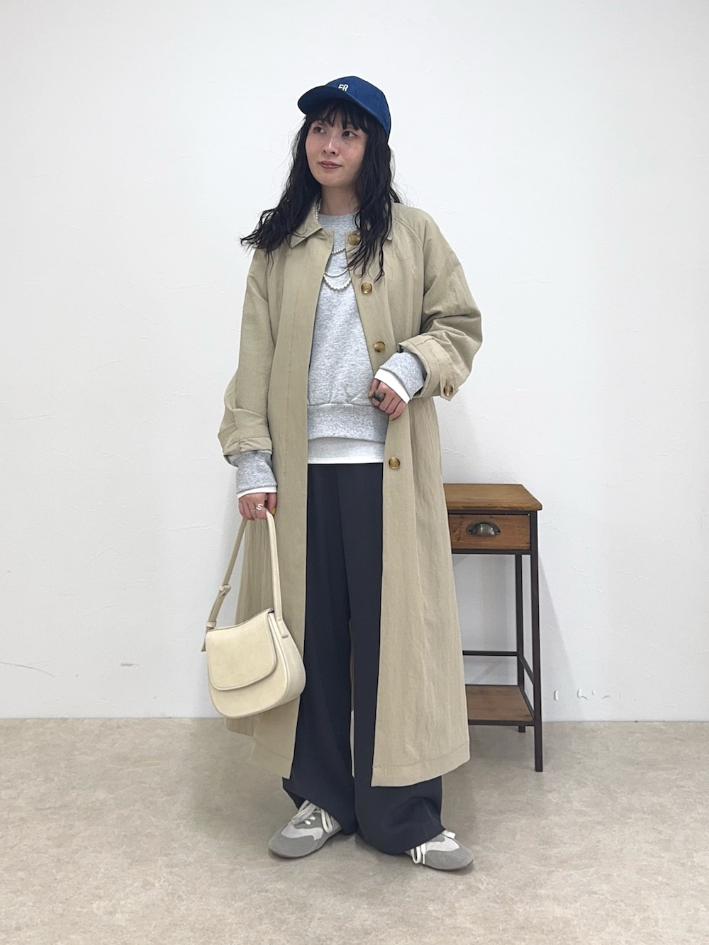 ベージュ系のステンカラーコート、グレー系のスウェット、ホワイト系のTシャツ/カットソーを着用したレディースの春コーディネートの4枚目の写真