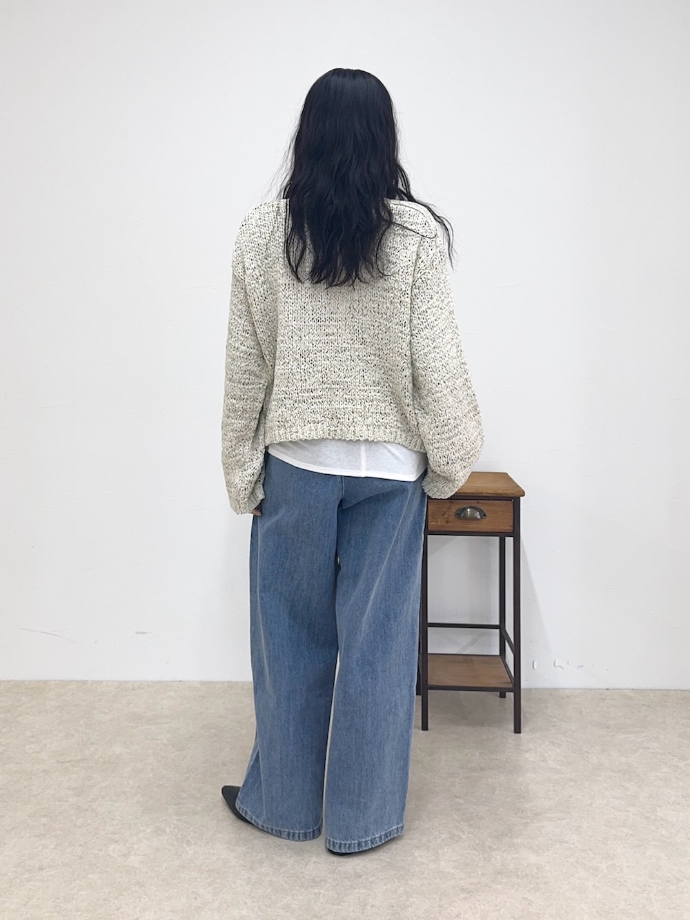 ベージュ系のニット/セーター、ホワイト系のTシャツ/カットソー、ブルー系のデニムパンツを着用したレディースの春コーディネートの3枚目の写真