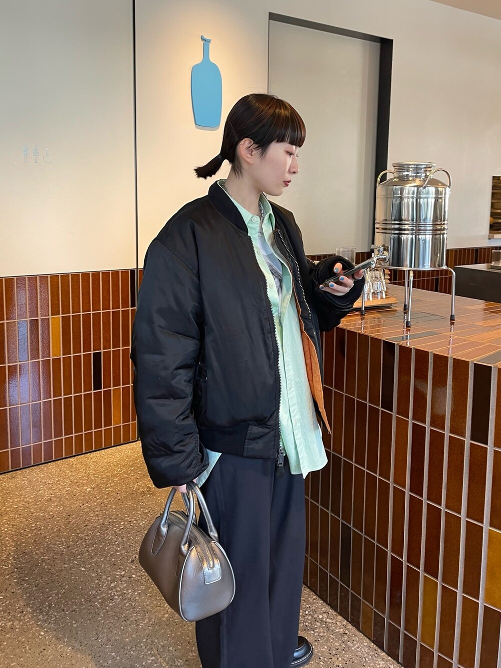 グリーン系のシャツ/ブラウス、ブラック系のその他パンツ、ブラック系のローファーを着用したレディースの冬コーディネートの3枚目の写真