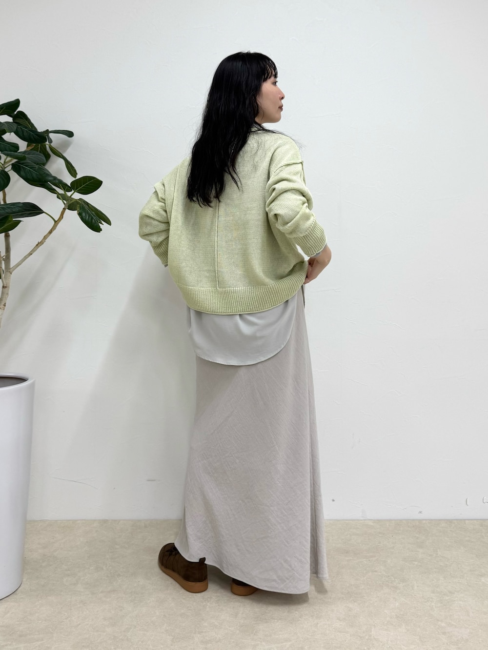 グレー系のシャツ/ブラウス、グリーン系のニット/セーター、ベージュ系のスカートを着用したレディースの春コーディネートの3枚目の写真