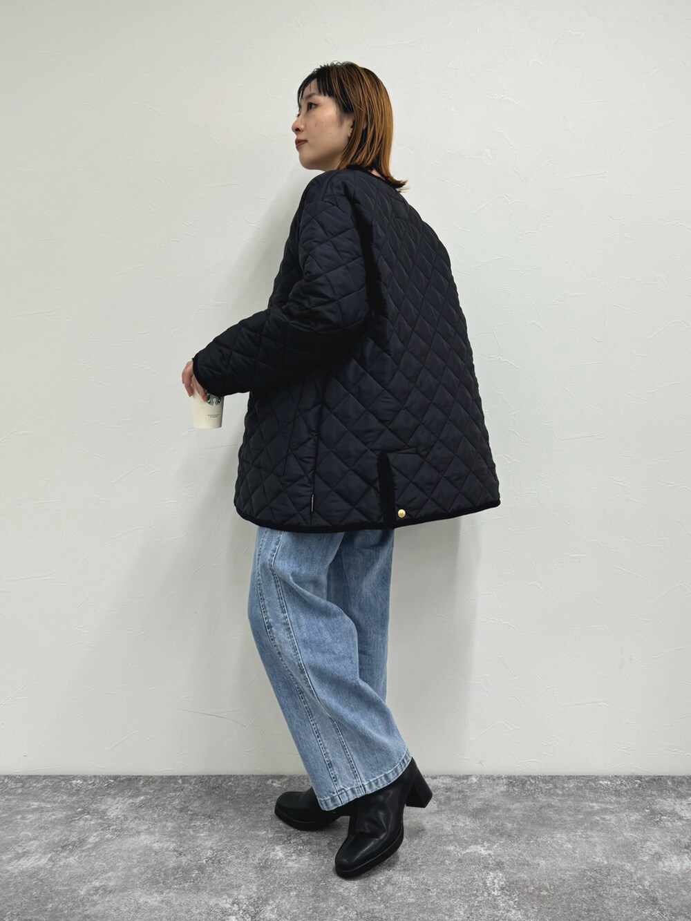 ブラック系のブルゾン、ホワイト系のTシャツ/カットソー、ブルー系のデニムパンツを着用したレディースの夏コーディネートの3枚目の写真