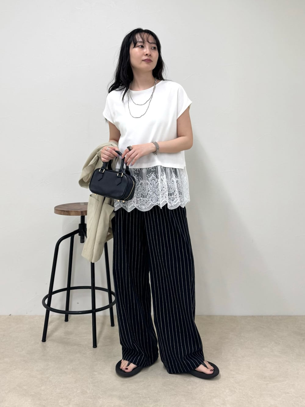 ブラック系のその他パンツ、ブラック系のサンダル、ホワイト系のTシャツ/カットソーを着用したレディースの春コーディネートの3枚目の写真
