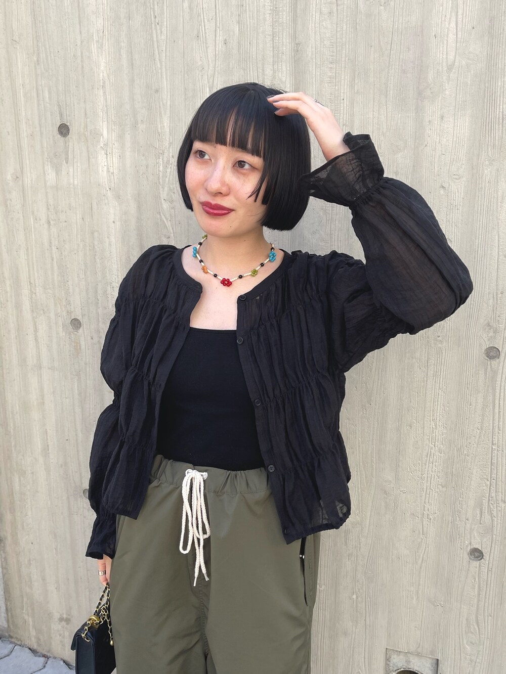 ブラック系のシャツ/ブラウス、グリーン系のカーゴパンツ、ブラック系のショルダーバッグを着用したレディースの春コーディネートの3枚目の写真