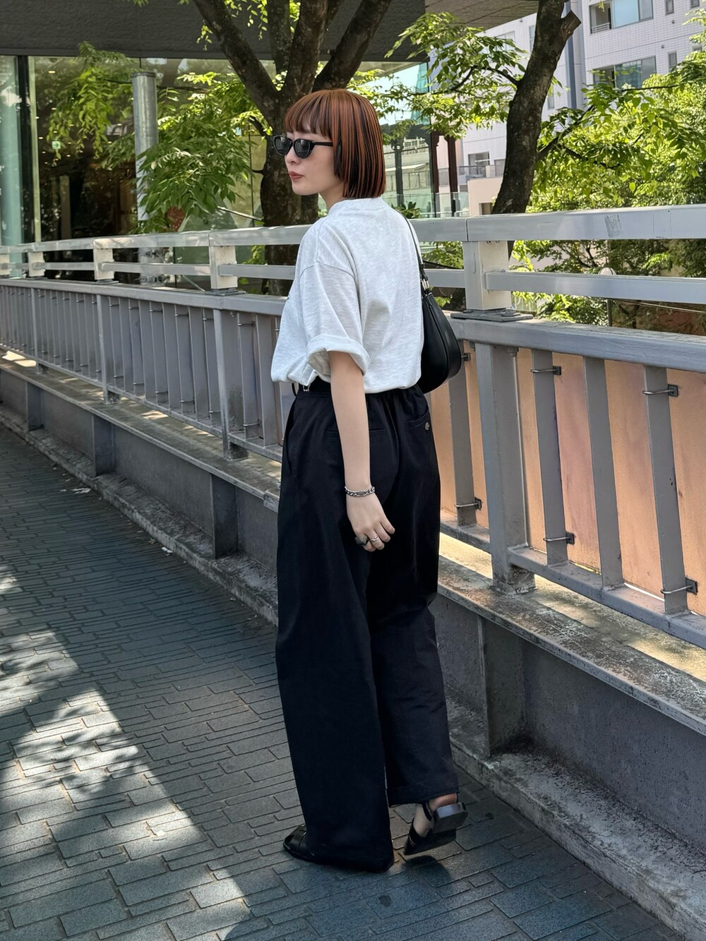 グレー系のTシャツ/カットソー、ブラック系のチノパンツを着用したレディースの春コーディネートの4枚目の写真