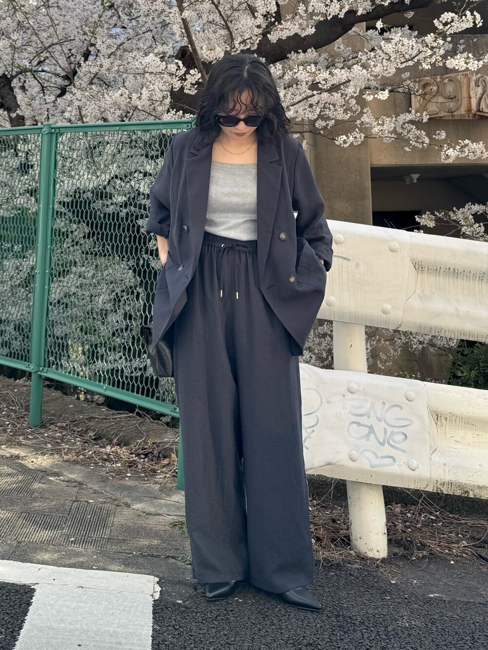 ブルー系のテーラードジャケット、ブルー系のその他パンツ、ブラック系のショルダーバッグを着用したレディースの春コーディネートの3枚目の写真