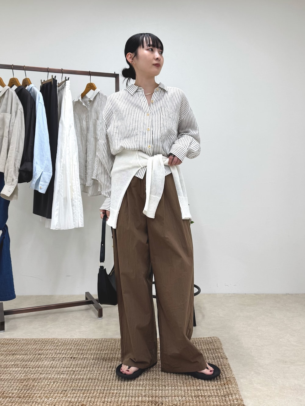 ベージュ系のシャツ/ブラウス、ブラウン系のその他パンツ、ホワイト系のニット/セーターを着用したレディースの春コーディネートの5枚目の写真