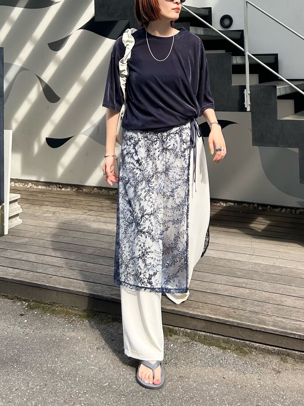 ブルー系のスカート、ホワイト系のその他パンツ、グレー系のサンダルを着用したレディースの夏コーディネートの2枚目の写真