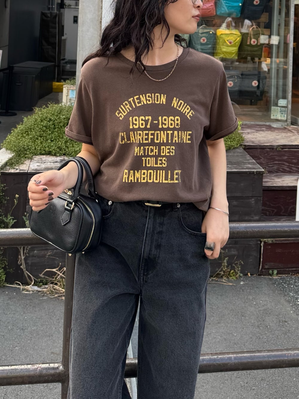 ブラウン系のTシャツ/カットソー、ブラック系のデニムパンツ、ブラック系のショルダーバッグを着用したレディースの夏コーディネートの3枚目の写真