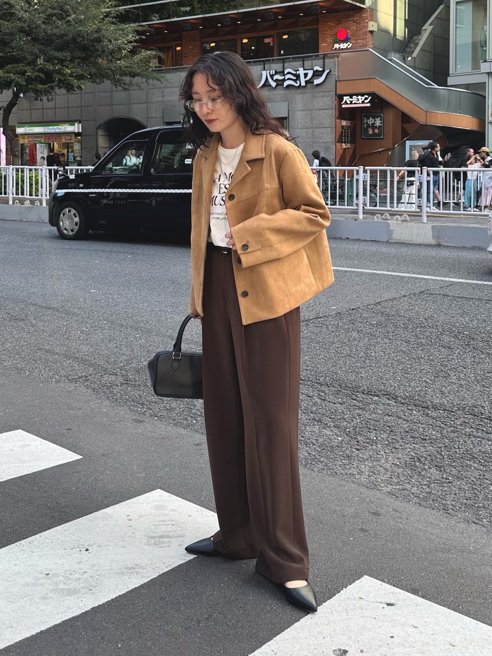 ベージュ系のダウンジャケット/コート、ホワイト系のTシャツ/カットソー、ブラウン系のスラックスを着用したレディースの秋コーディネートの2枚目の写真