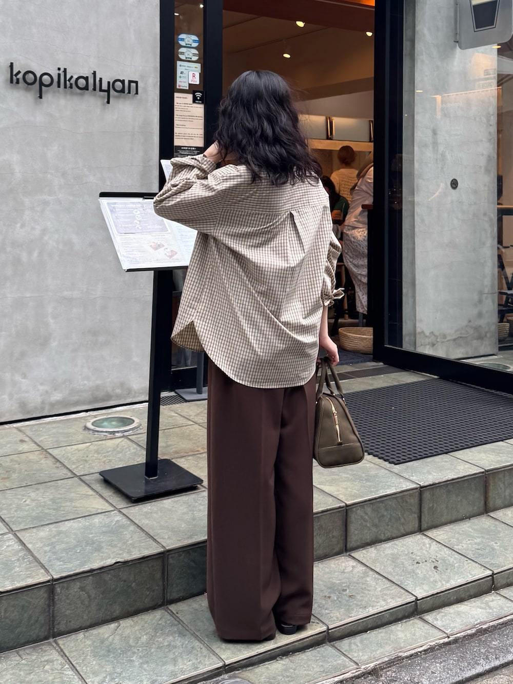 ベージュ系のシャツ/ブラウス、ブラウン系のスラックス、グリーン系のショルダーバッグを着用したレディースの秋コーディネートの3枚目の写真