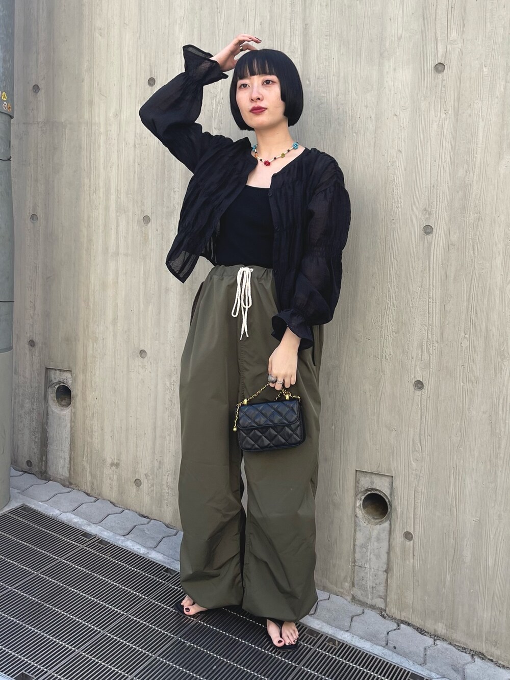 ブラック系のシャツ/ブラウス、グリーン系のカーゴパンツ、ブラック系のショルダーバッグを着用したレディースの春コーディネートの2枚目の写真