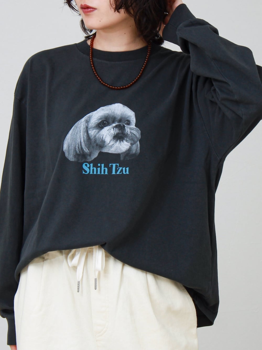 ブラック系のTシャツ/カットソー、ホワイト系のその他パンツ、ブラウン系のネックレスを着用したレディースの夏コーディネートの2枚目の写真