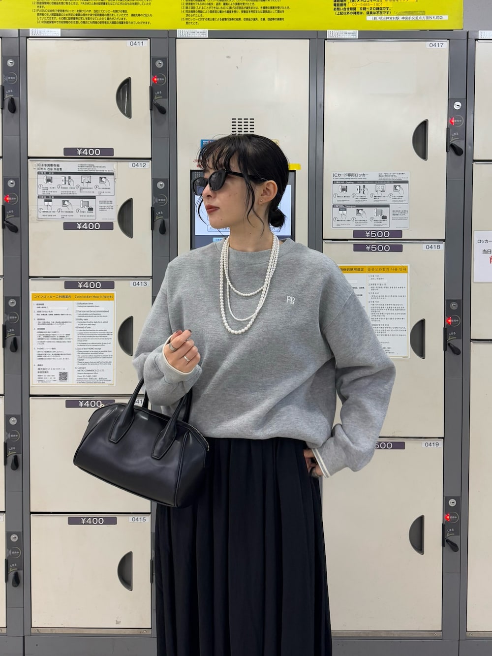 グレー系のスウェット、ブラック系のスカートを着用したレディースの冬コーディネートの6枚目の写真