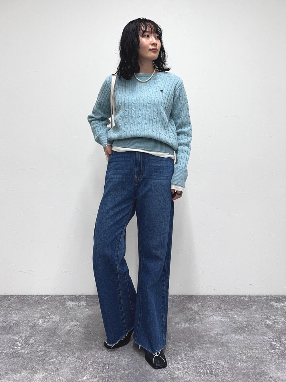 ブルー系のニット/セーター、ブルー系のデニムパンツ、ホワイト系のTシャツ/カットソーを着用したレディースの冬コーディネートの3枚目の写真