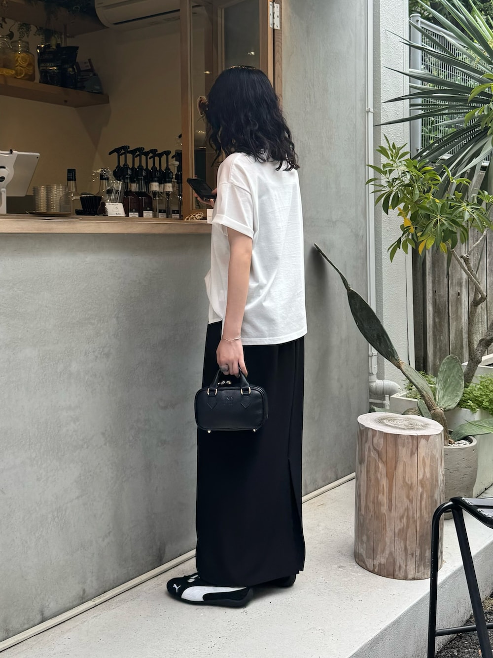 ホワイト系のTシャツ/カットソー、ブラック系のスカート、ブラック系のショルダーバッグを着用したレディースの夏コーディネートの2枚目の写真