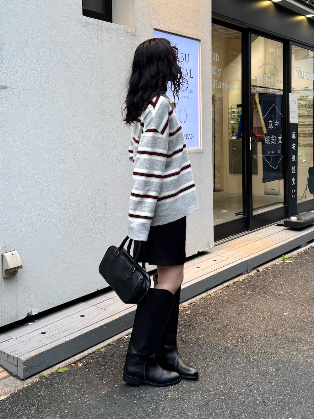 グレー系のニット/セーター、ブラック系のショルダーバッグを着用したレディースの秋コーディネートの4枚目の写真