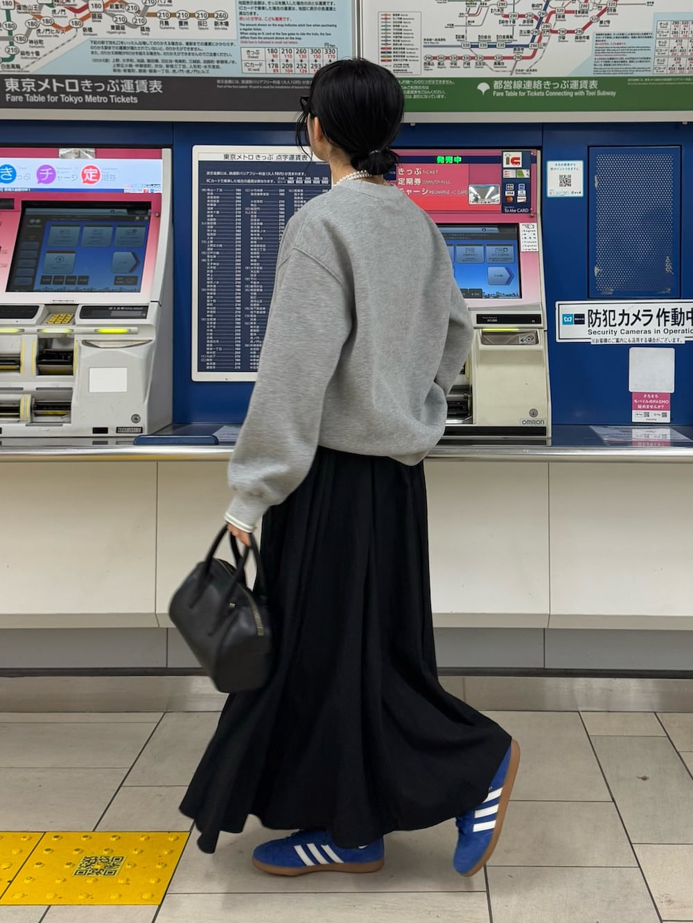 グレー系のスウェット、ブラック系のスカートを着用したレディースの冬コーディネートの2枚目の写真