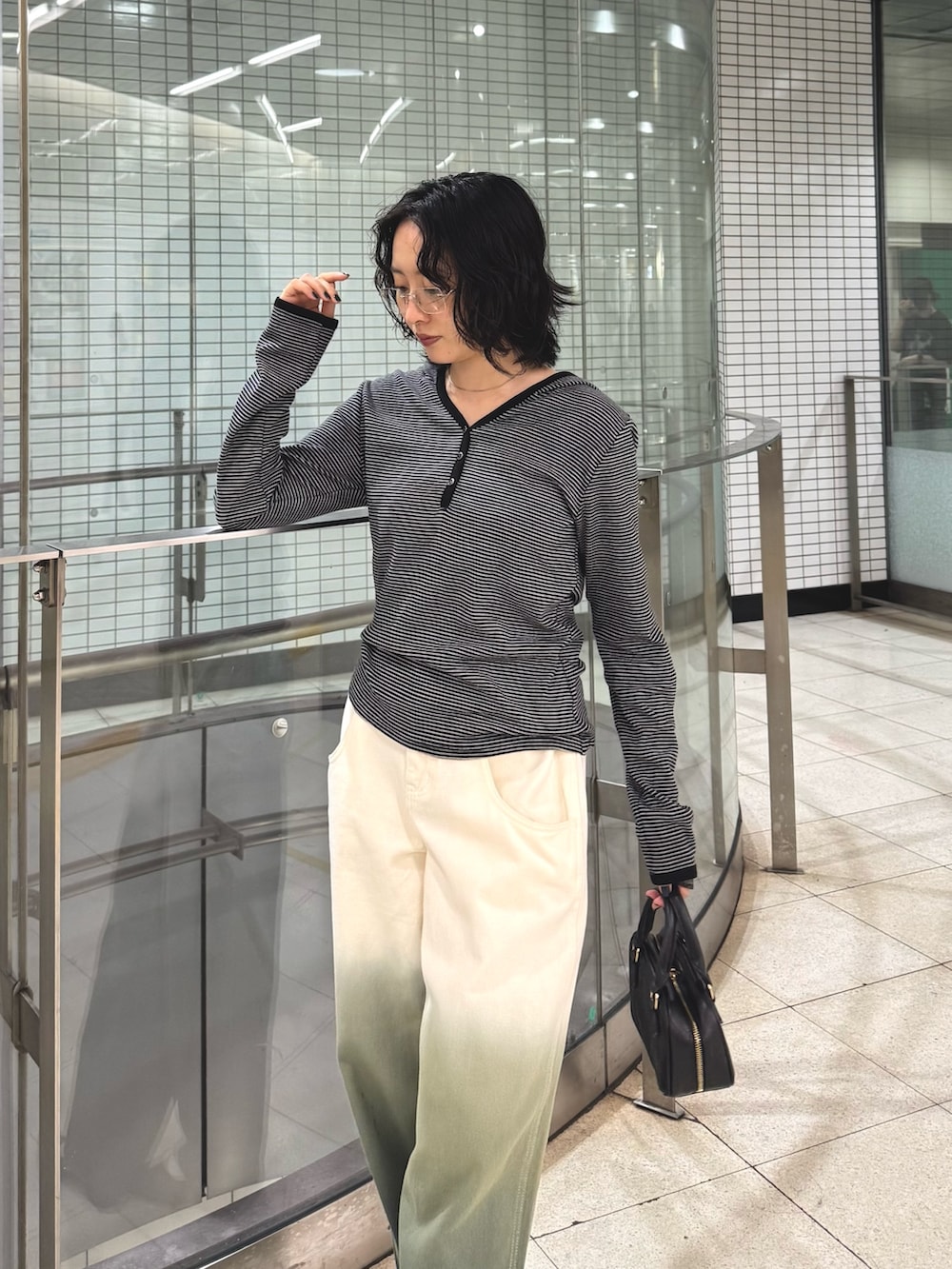 ブラック系のTシャツ/カットソー、グリーン系のデニムパンツを着用したレディースの秋コーディネートの3枚目の写真