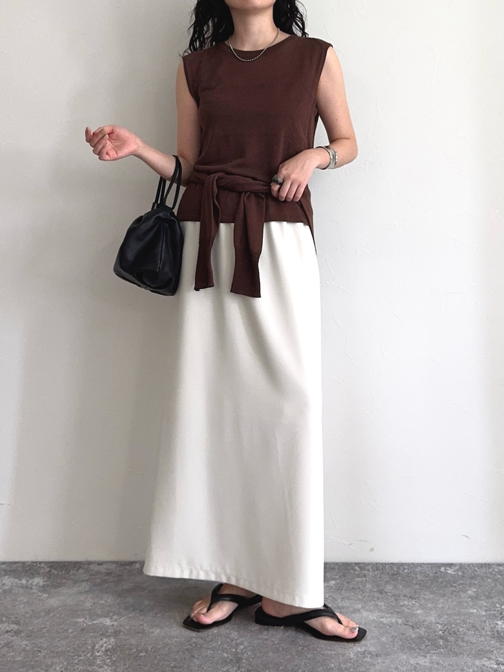 ブラウン系のタンクトップ、ブラウン系のカーディガン/ボレロ、ホワイト系のスカートを着用したレディースの夏コーディネートの5枚目の写真