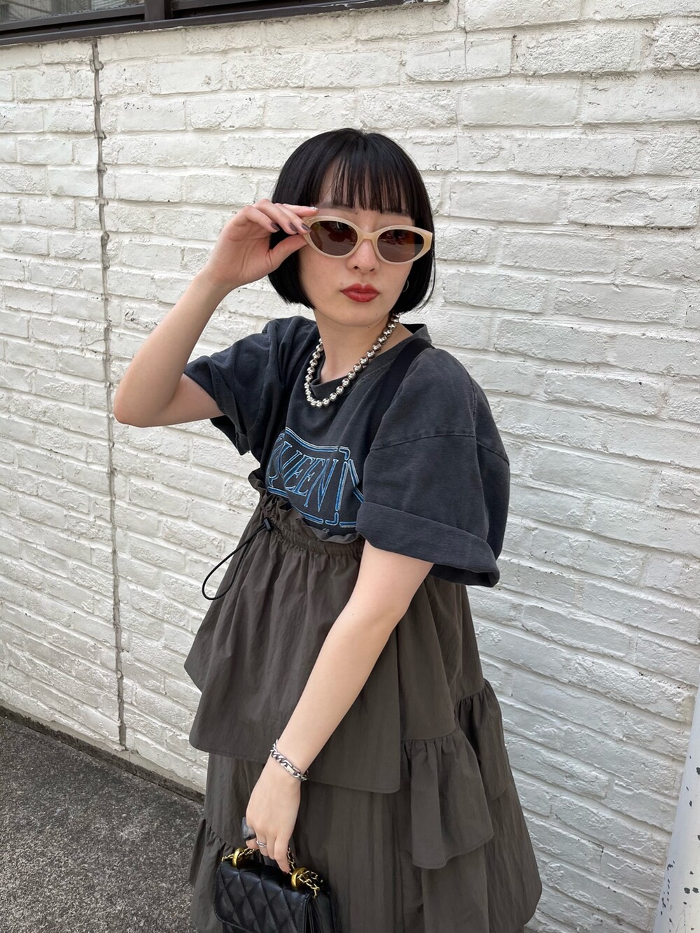 ブラック系のTシャツ/カットソー、グリーン系のワンピース、ブラック系のショルダーバッグを着用したレディースの春コーディネートの3枚目の写真