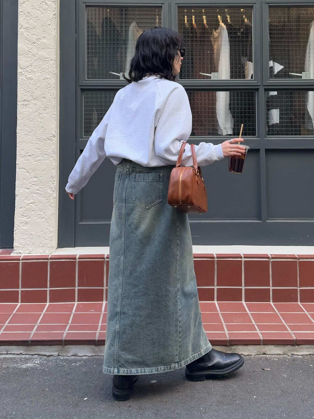 ブルー系のデニムスカート、イエロー系のショルダーバッグを着用したレディースの冬コーディネートの3枚目の写真