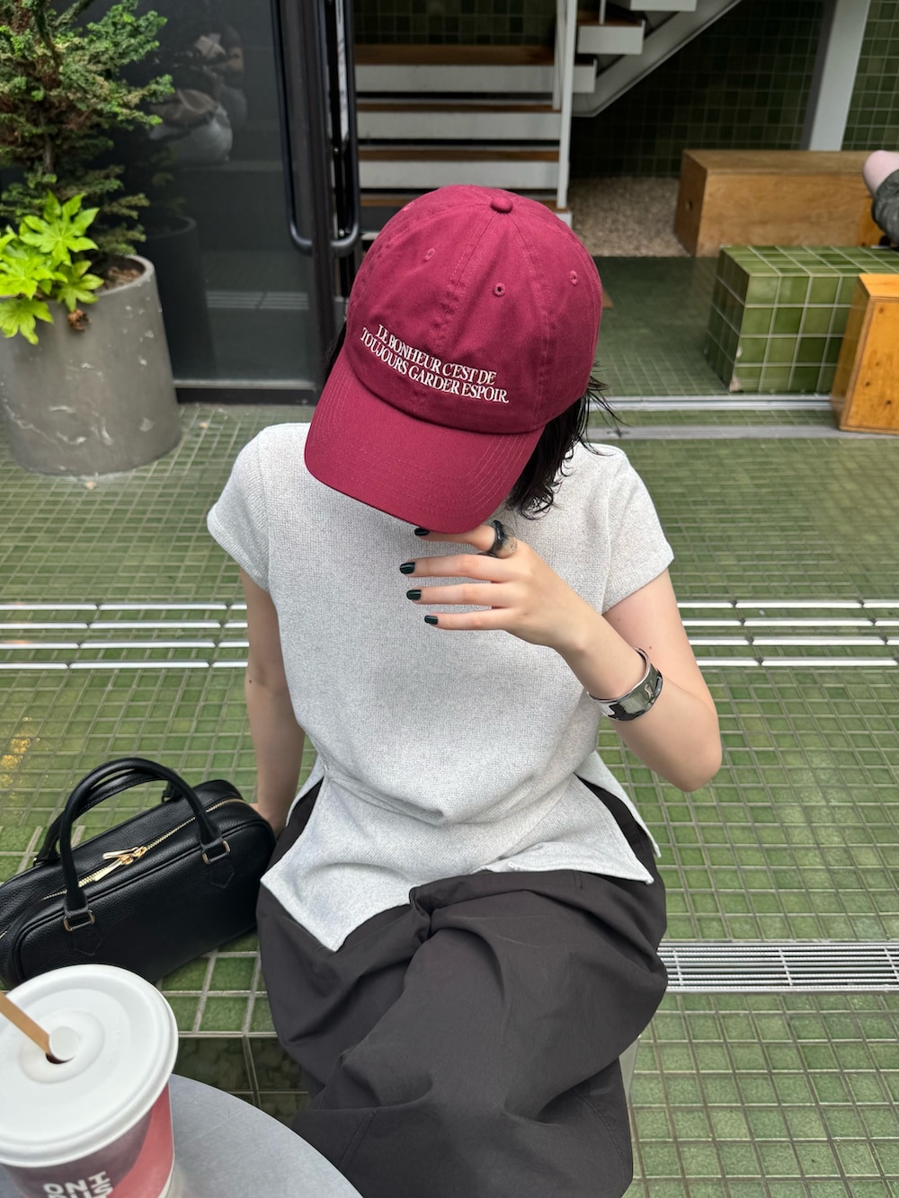 ホワイト系のTシャツ/カットソー、ブラック系のその他パンツ、レッド系のキャップを着用したレディースの夏コーディネートの7枚目の写真