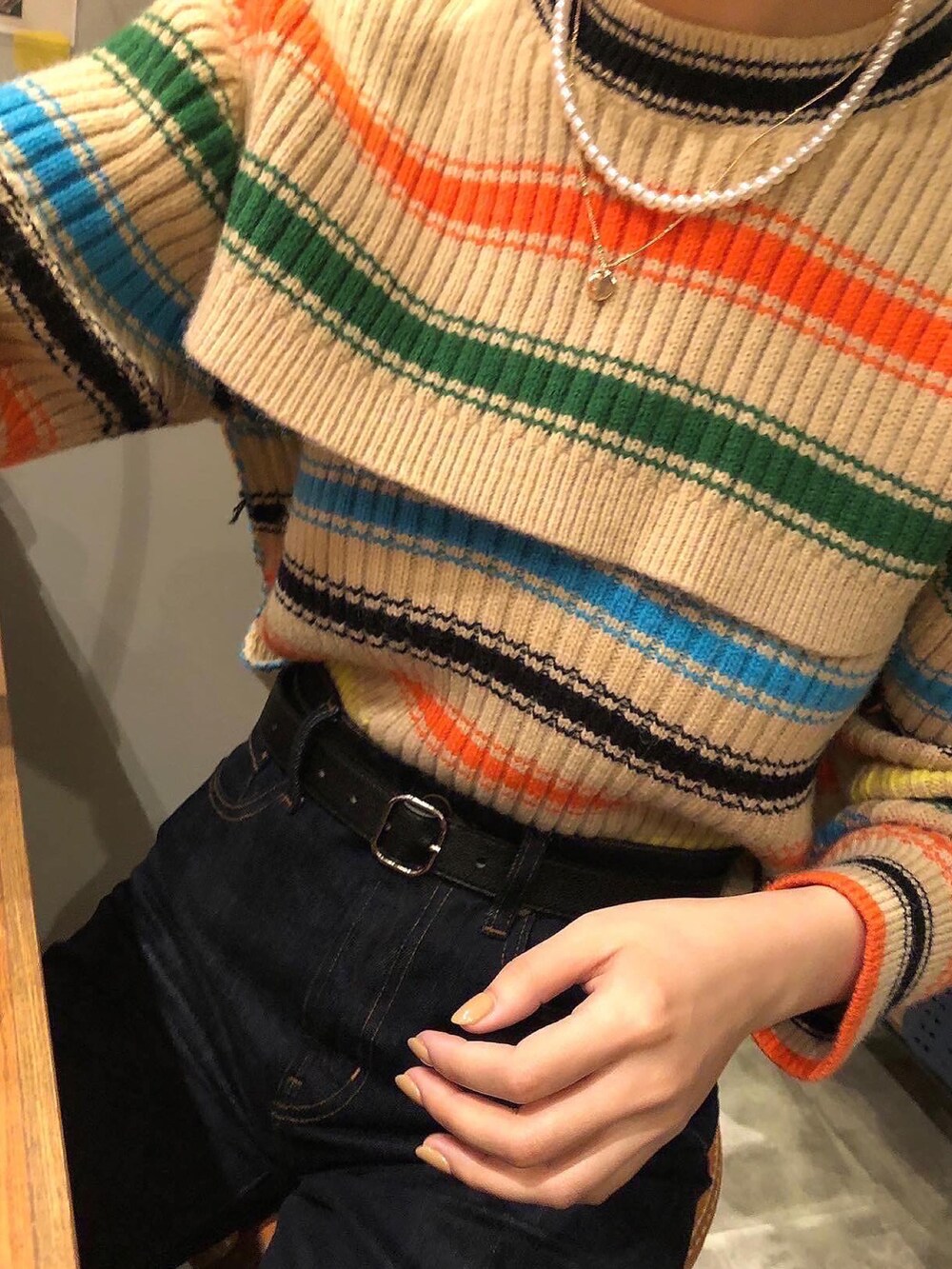 ブラック系のデニムパンツ、その他のニット/セーター、ホワイト系のネックレスを着用したレディースの春コーディネートの2枚目の写真