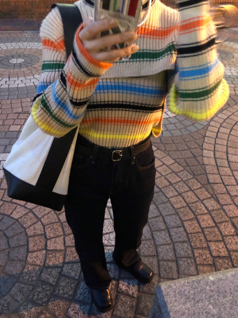ブラック系のデニムパンツ、その他のニット/セーター、ホワイト系のネックレスを着用したレディースの春コーディネートの4枚目の写真