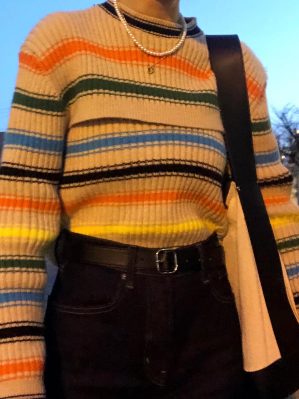 ブラック系のデニムパンツ、その他のニット/セーター、ホワイト系のネックレスを着用したレディースの春コーディネートの3枚目の写真