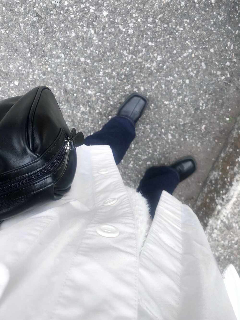 ブラック系のデニムパンツ、ホワイト系のベストを着用したレディースの春コーディネートの2枚目の写真