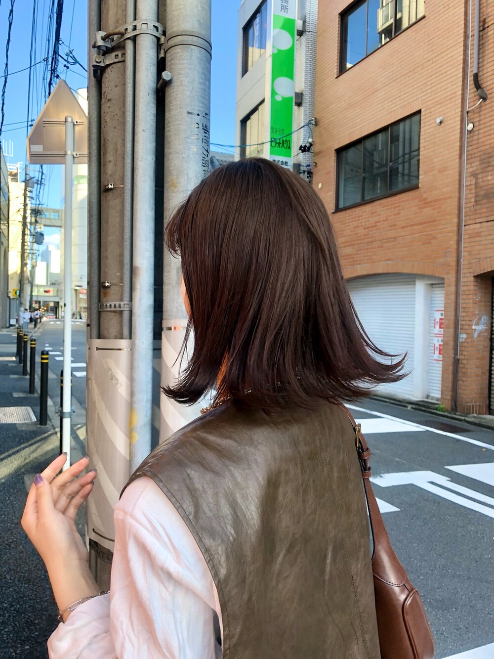 ブラウン系のベストを着用したレディースの春コーディネートの3枚目の写真