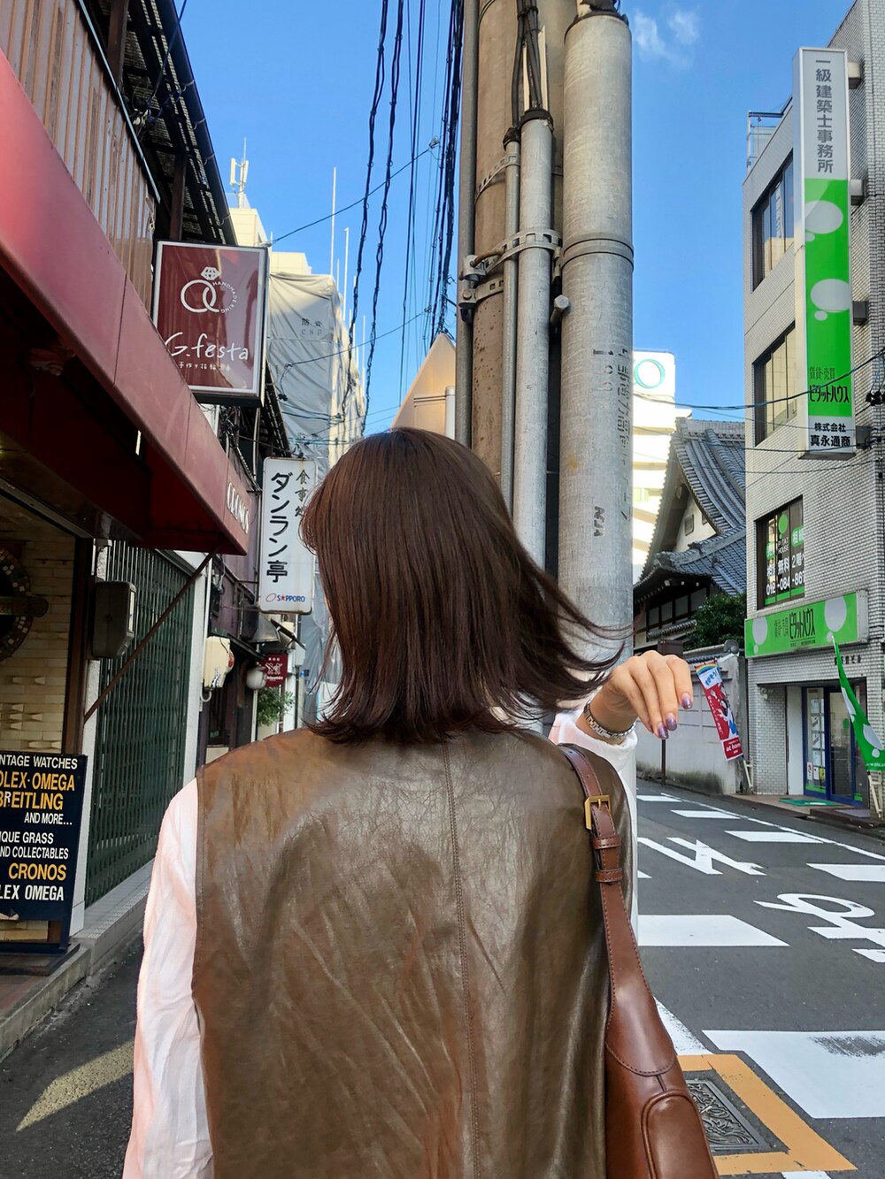 ブラウン系のベストを着用したレディースの春コーディネートの2枚目の写真