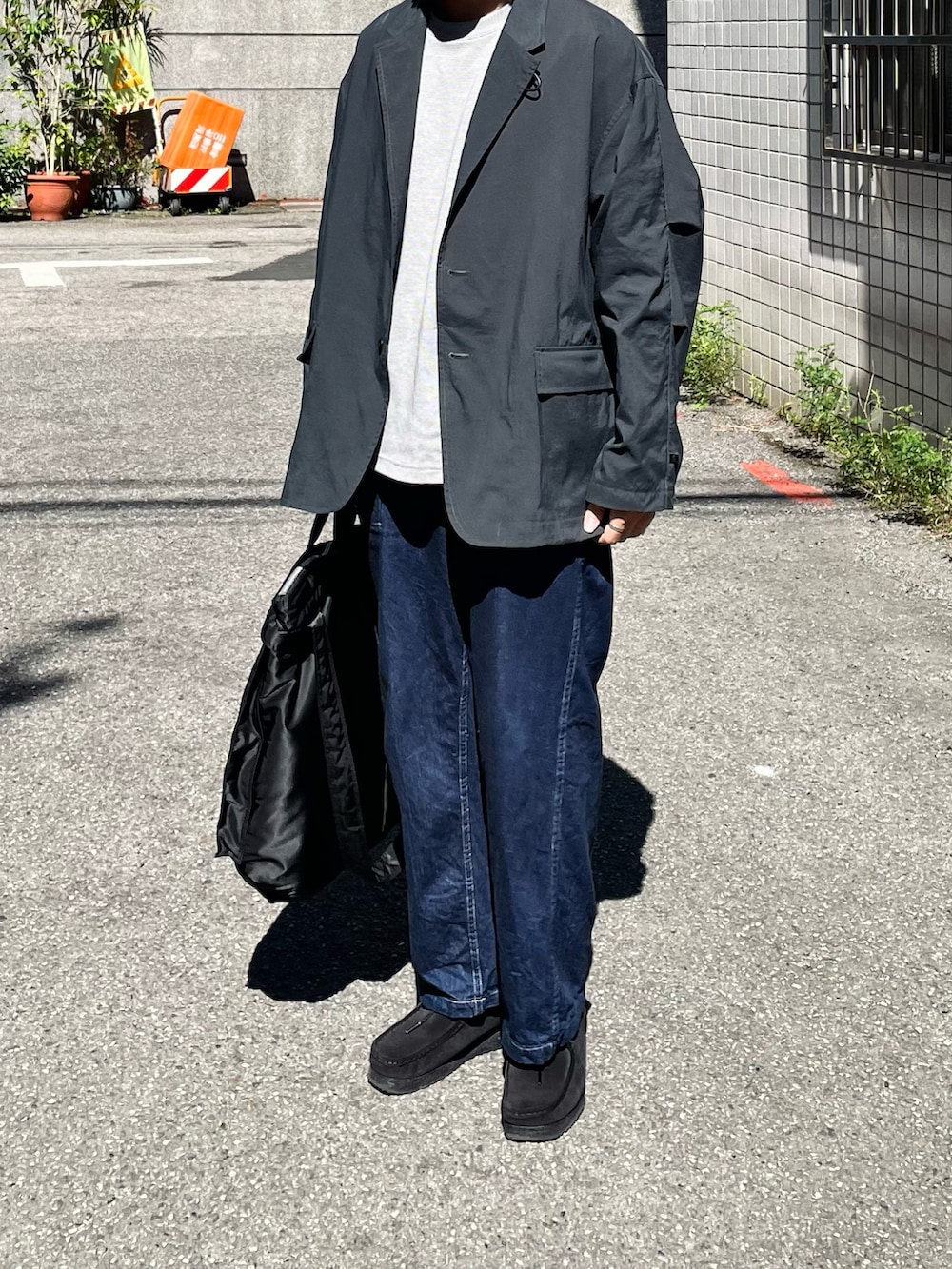 グレー系のTシャツ/カットソー、ブラック系のその他アウター、ブルー系のデニムパンツを着用したメンズの秋コーディネートの5枚目の写真