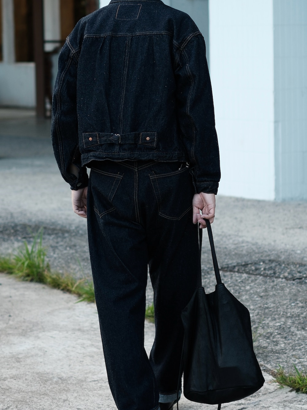 ブルー系のデニムパンツ、ブラック系のブーツ、ブラック系のトートバッグを着用したメンズの冬コーディネートの3枚目の写真